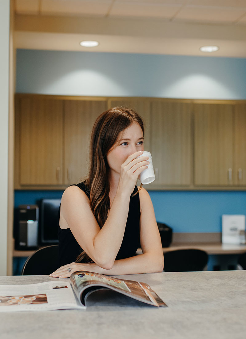 Image of a woman drinking coffee, used for the pilot lounge amenity.