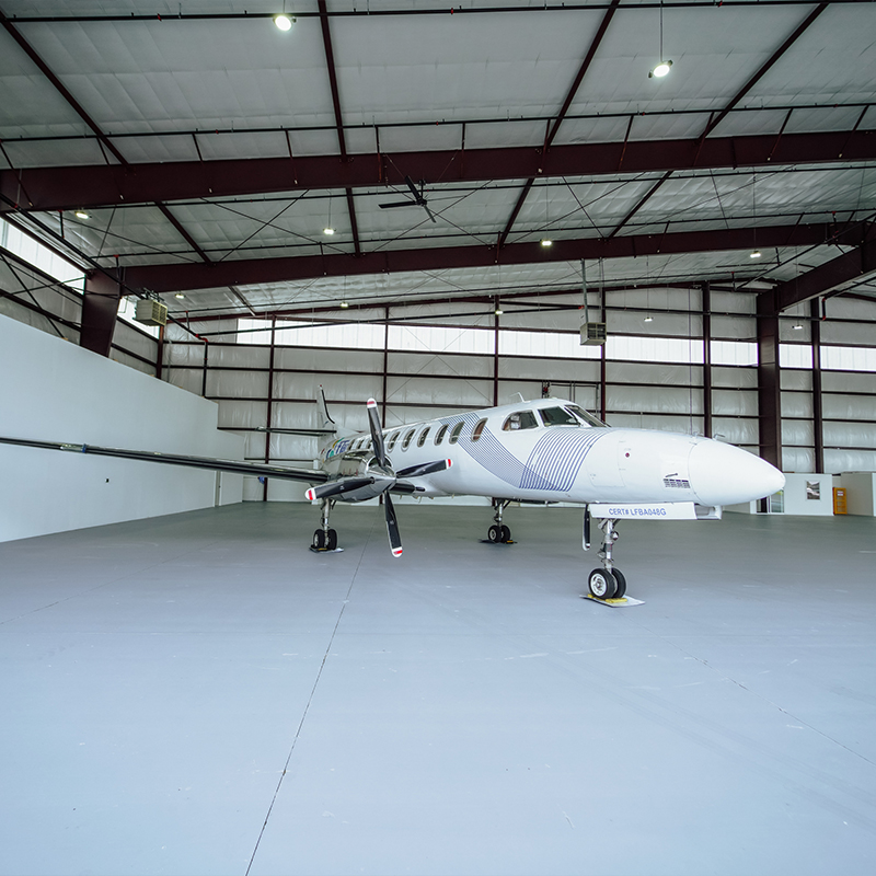 Image of the interior of a hangar that houses a medium sized plane.